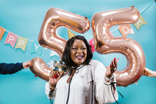 55th birthday party celebration with balloons, banners, and themed tableware and decorations