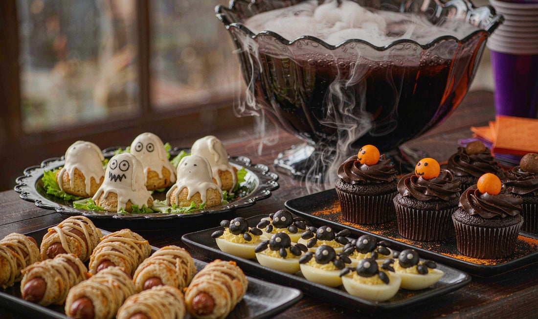 Halloween party food spread with mummy hot dogs, spider deviled eggs, and spooky punch