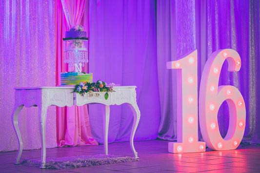 Sweet 16 birthday party celebration with balloons, banners, and themed tableware and decorations