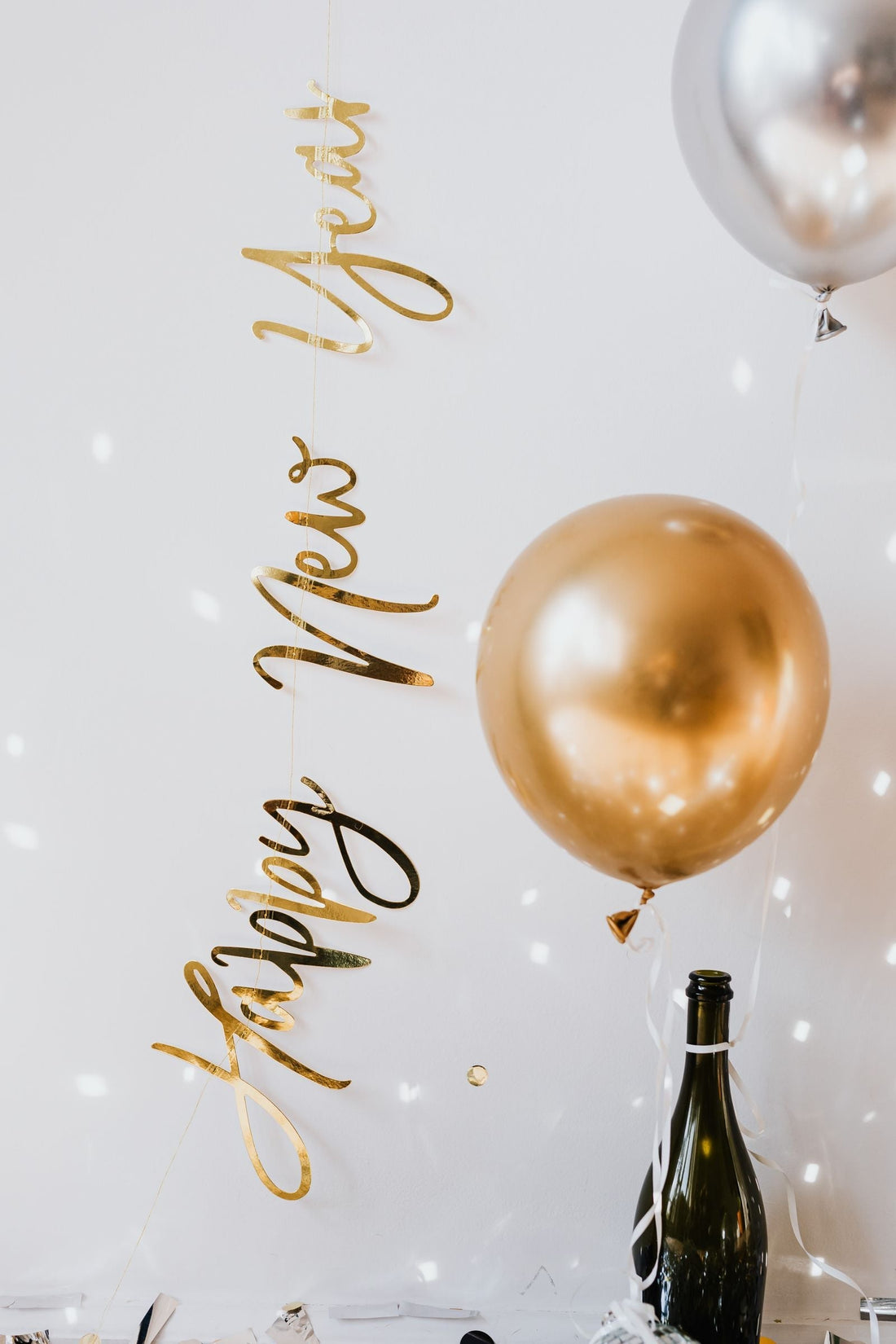 New Year's Eve party table with gold decorations, party hats, and new year party supplies