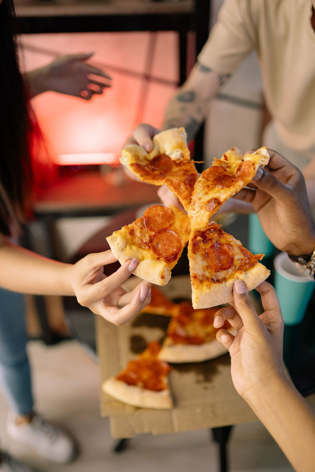 Pizza party with pizza slice decorations, red checkered tableware, and pizza party supplies