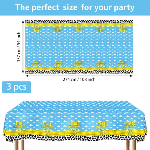 Flat lay of three cartoon 3rd birthday tablecloths featuring rocket and cow print pattern on white background