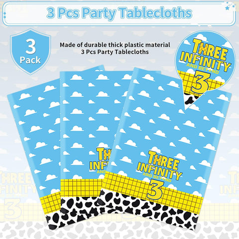 Cartoon 3rd birthday tablecloth draped on party table with matching rocket and cow themed decorations