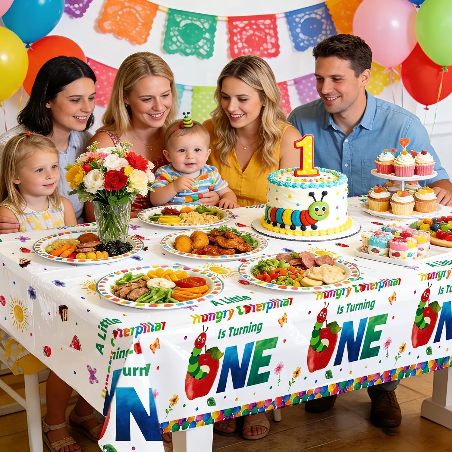 First birthday party scene for kids with caterpillar themed tablecloth and insect decorations