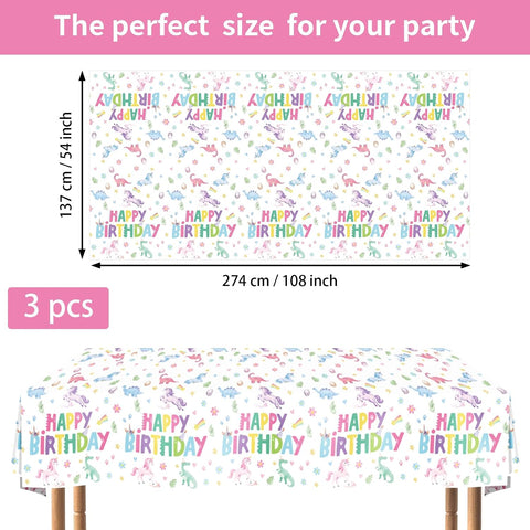 Flat lay of three dino unicorn birthday tablecloths with rainbow dinosaurs and unicorns