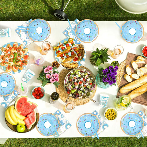 Full set of blue donut themed plates napkins cups cutlery flat lay