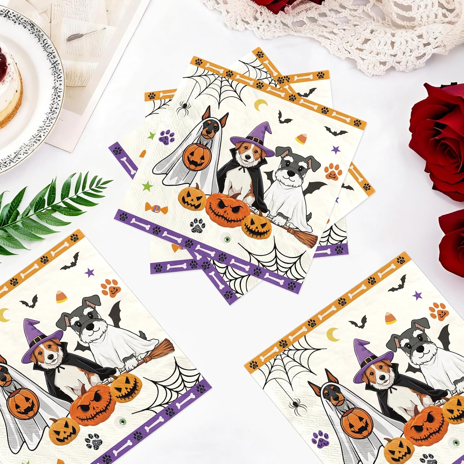 Flat lay of the Halloween ghost dog napkins and costumed dogs