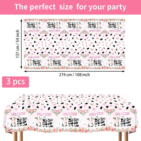 Flat lay of three Holy Cow I'm One tablecloths with cow print pattern