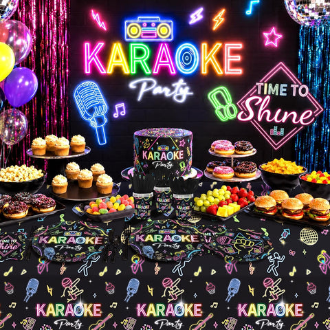 Complete karaoke neon party table setup with plates, napkins, cups, cutlery, food spread and neon KARAOKE Party backdrop