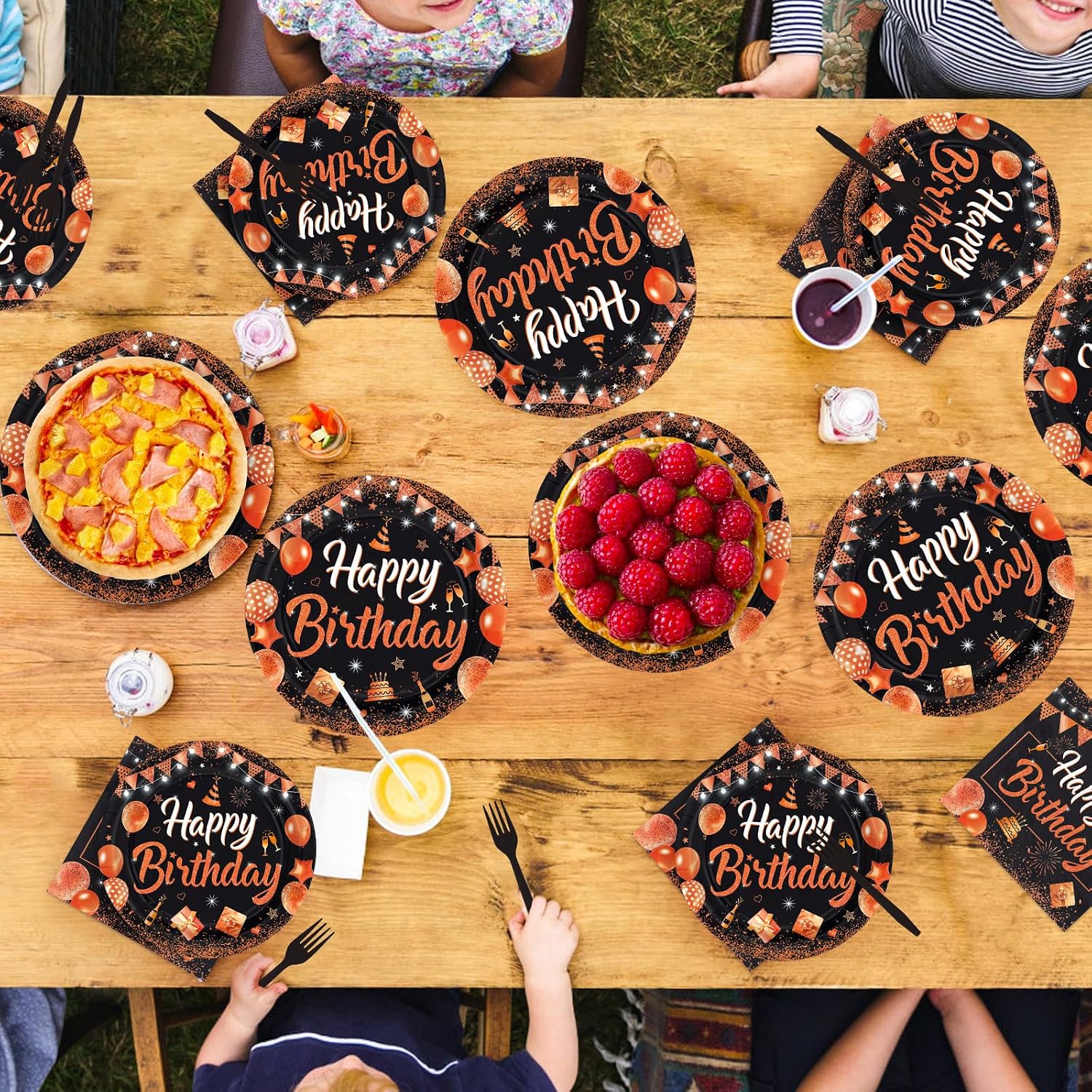 Black and orange glitter birthday plates laid out for guests