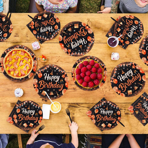 Black and orange glitter birthday plates laid out for guests